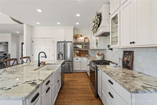 2164 Northbridge Trl, Troy, OH 45373 - kitchen featuring appliances with stainless steel finishes, a sink, custom range hood, white cabinets, and an island with sink