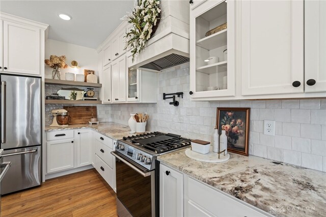 2164 Northbridge Trl, Troy, OH 45373 - kitchen featuring stainless steel appliances, custom exhaust hood, white cabinets, glass insert cabinets, and light stone counters
