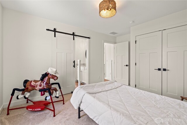 2164 Northbridge Trl, Troy, OH 45373 - carpeted bedroom with a barn door, baseboards, and a closet