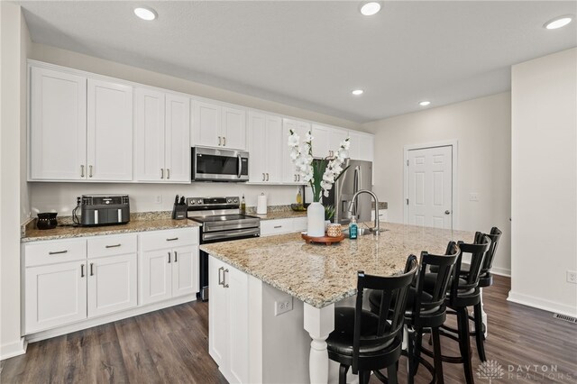 3059 Canvasback Ct, Franklin Twp, OH 45005 - kitchen with white cabinets, appliances with stainless steel finishes, recessed lighting, and a center island with sink