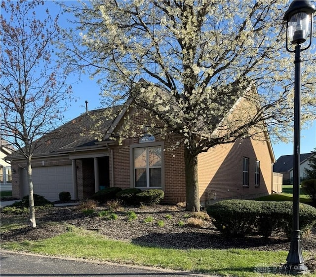 view of front facade featuring brick siding and a garage