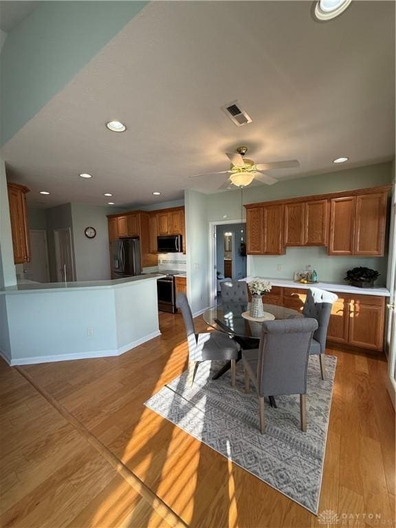 dining space with visible vents, ceiling fan, baseboards, and light wood-style flooring