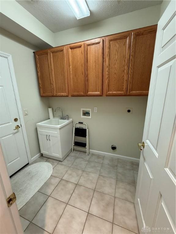 washroom featuring light tile patterned floors, washer hookup, a sink, hookup for an electric dryer, and cabinet space