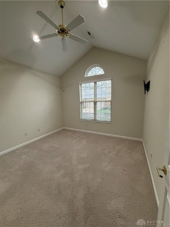 carpeted spare room with lofted ceiling, visible vents, baseboards, and ceiling fan