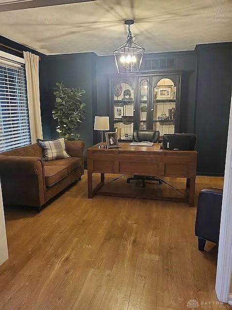 home office featuring a chandelier and wood finished floors