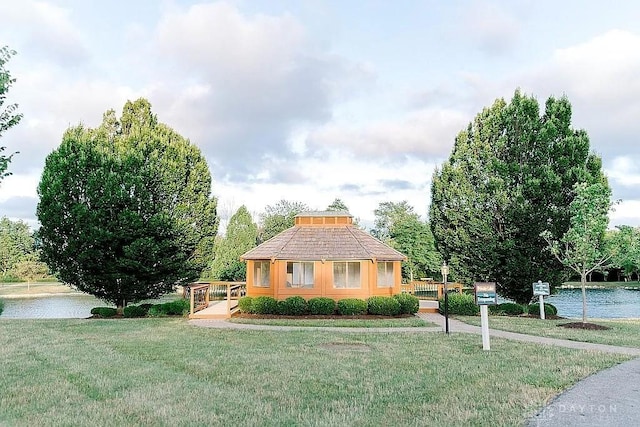 view of front of home featuring a water view and a front lawn