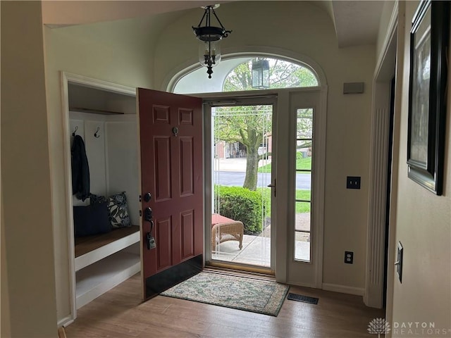 foyer entrance with baseboards and wood finished floors
