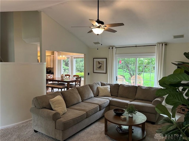 living room featuring a ceiling fan, a healthy amount of sunlight, carpet floors, and vaulted ceiling