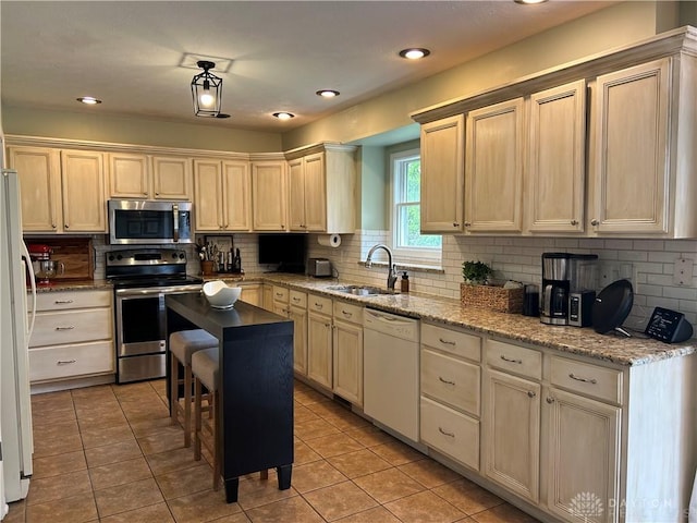 kitchen featuring a sink, stainless steel appliances, light tile patterned flooring, and decorative backsplash