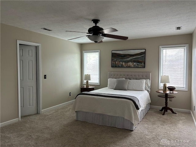 bedroom with baseboards, visible vents, and light colored carpet