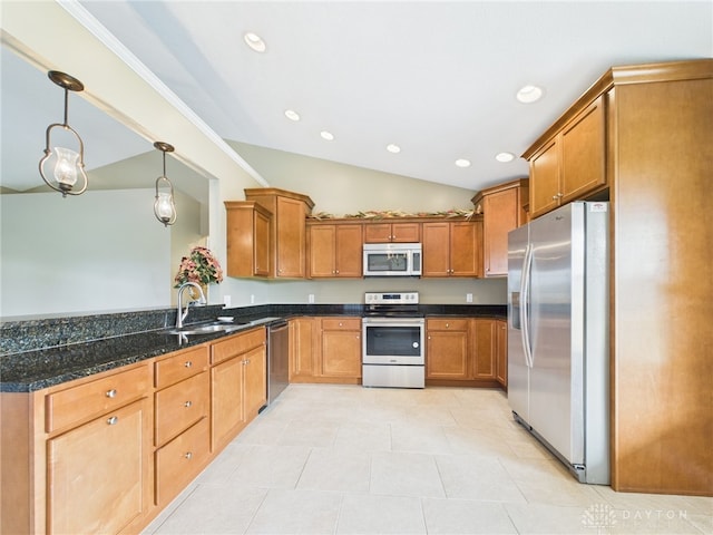 kitchen featuring brown cabinetry, dark stone countertops, a sink, lofted ceiling, and stainless steel appliances