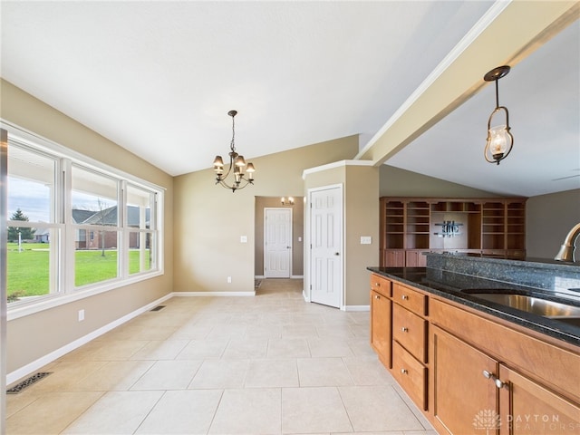 kitchen with a sink, hanging light fixtures, a notable chandelier, and vaulted ceiling
