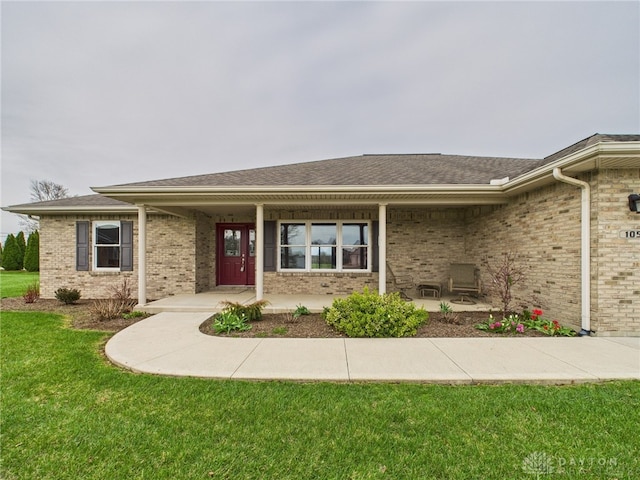 ranch-style house with brick siding, a front lawn, and covered porch