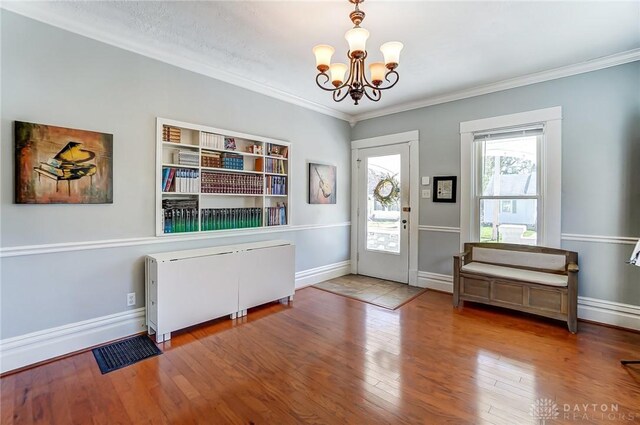 357 High St, Wilmington, OH 45177 - foyer entrance featuring an inviting chandelier, visible vents, baseboards, ornamental molding, and wood finished floors