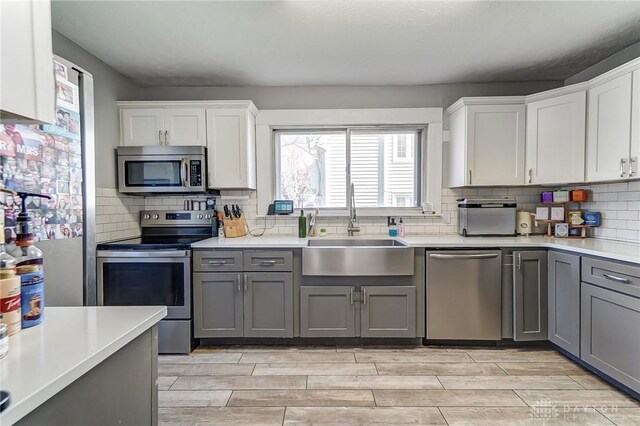 357 High St, Wilmington, OH 45177 - kitchen featuring gray cabinetry, a sink, stainless steel appliances, and light countertops