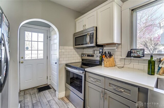 357 High St, Wilmington, OH 45177 - kitchen with light wood-type flooring, stainless steel appliances, light countertops, and decorative backsplash