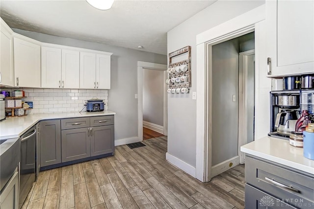 357 High St, Wilmington, OH 45177 - kitchen with light wood-style floors, tasteful backsplash, baseboards, light countertops, and gray cabinetry