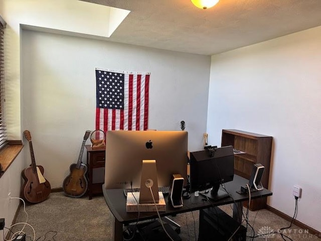carpeted home office with baseboards and a skylight