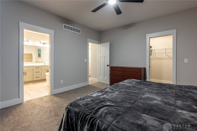 bedroom featuring baseboards, light carpet, connected bathroom, visible vents, and ceiling fan