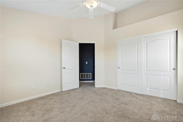 unfurnished bedroom featuring a closet, carpet flooring, baseboards, and visible vents