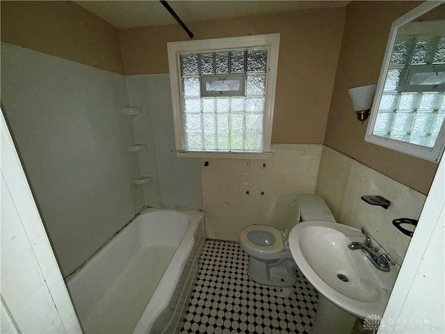 1029 Cumberland Ave, Dayton, OH 45406 - full bathroom featuring tile patterned flooring, a wainscoted wall, toilet, tile walls, and a sink