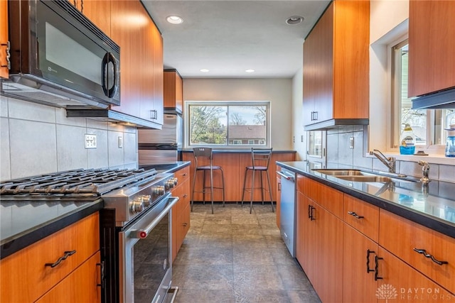 645 Brookfield Rd, Dayton, OH 45429 - kitchen with stainless steel appliances, tasteful backsplash, brown cabinets, recessed lighting, and dark stone finish flooring