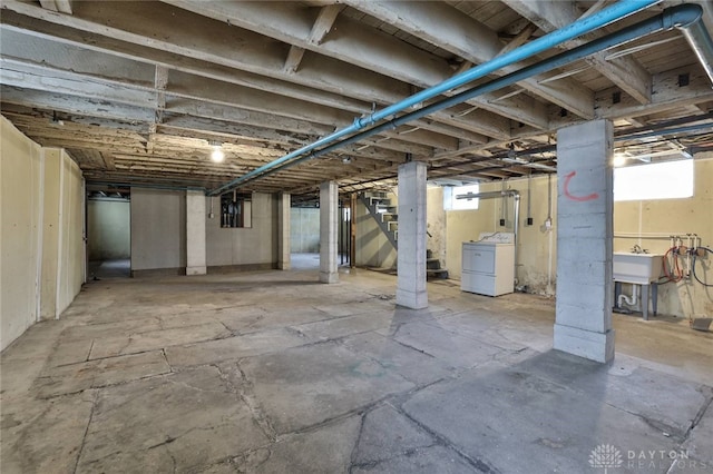 basement with a sink, stairway, and washer / dryer