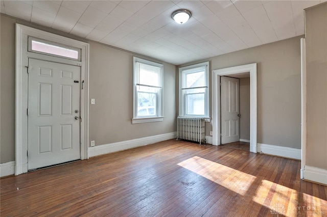 foyer featuring radiator heating unit, hardwood / wood-style floors, and baseboards
