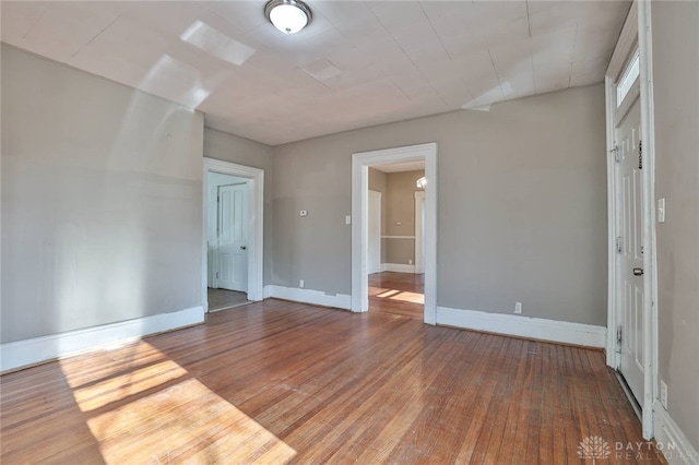 unfurnished room featuring hardwood / wood-style flooring and baseboards