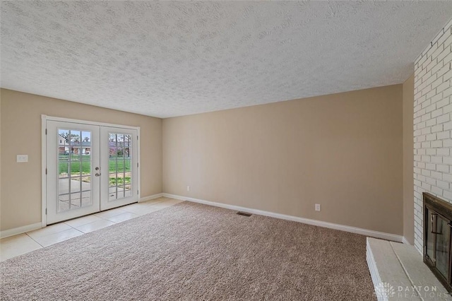 721 Trafalgar Ct, Middletown, OH 45044 - unfurnished living room with french doors, a textured ceiling, a fireplace, baseboards, and carpet floors