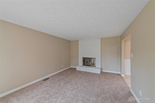 721 Trafalgar Ct, Middletown, OH 45044 - unfurnished living room featuring a textured ceiling, a fireplace, light carpet, and baseboards