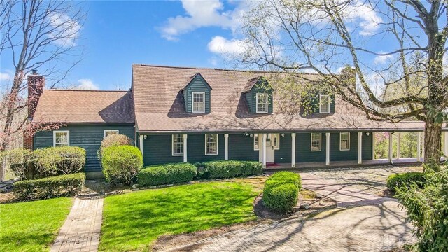 4600 Brown Rd, Sugarcreek Township, OH 45440 - cape cod-style house with a front lawn, covered porch, and a chimney