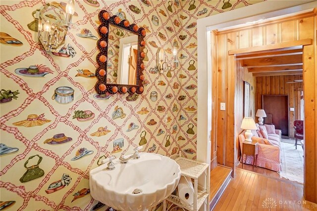4600 Brown Rd, Sugarcreek Township, OH 45440 - bathroom featuring wallpapered walls, hardwood / wood-style flooring, a sink, and wooden walls