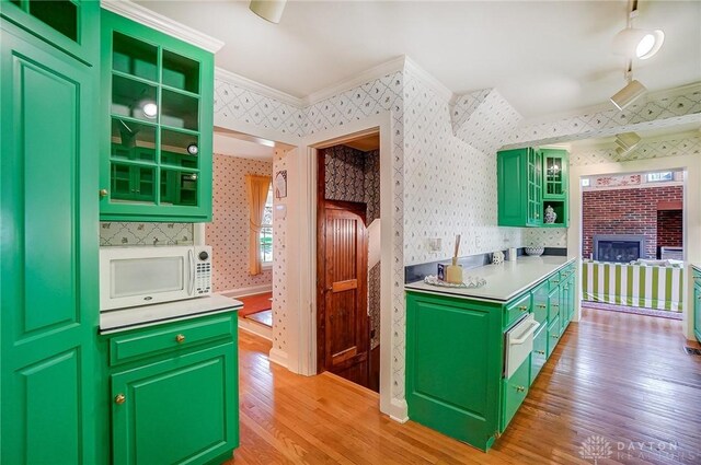 4600 Brown Rd, Sugarcreek Township, OH 45440 - kitchen with white microwave, wallpapered walls, green cabinets, light wood-style flooring, and ornamental molding
