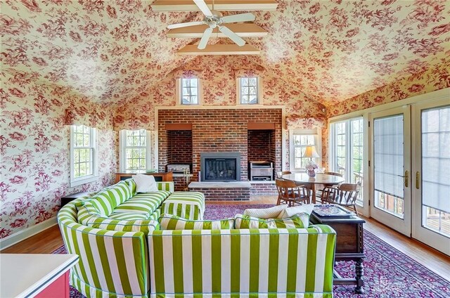 4600 Brown Rd, Sugarcreek Township, OH 45440 - living area featuring wallpapered walls, plenty of natural light, wood finished floors, a brick fireplace, and lofted ceiling
