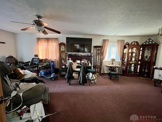 living area with a textured ceiling, ceiling fan, and carpet floors