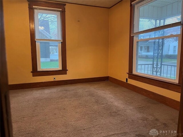 carpeted empty room featuring baseboards