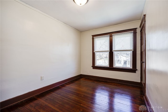 spare room with baseboards and dark wood finished floors