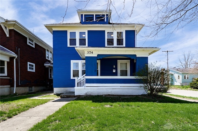 american foursquare style home with a porch and a front lawn