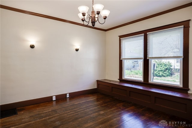 spare room with crown molding, an inviting chandelier, dark wood finished floors, visible vents, and baseboards