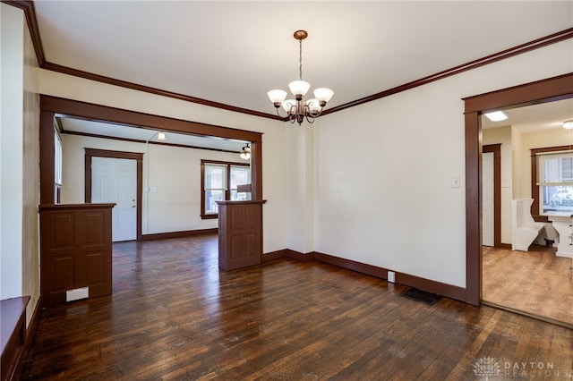 unfurnished room featuring visible vents, baseboards, dark wood-style flooring, a chandelier, and crown molding