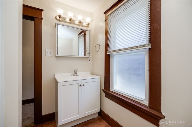 bathroom featuring plenty of natural light, vanity, and baseboards