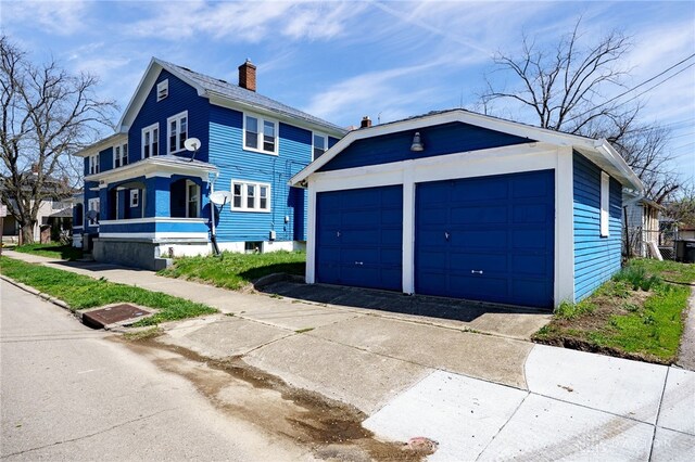 374 Kenwood Ave, Dayton, OH 45405 - view of front of house featuring a chimney, a detached garage, and an outdoor structure