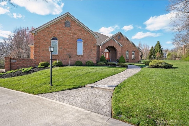 traditional home with a front yard and brick siding