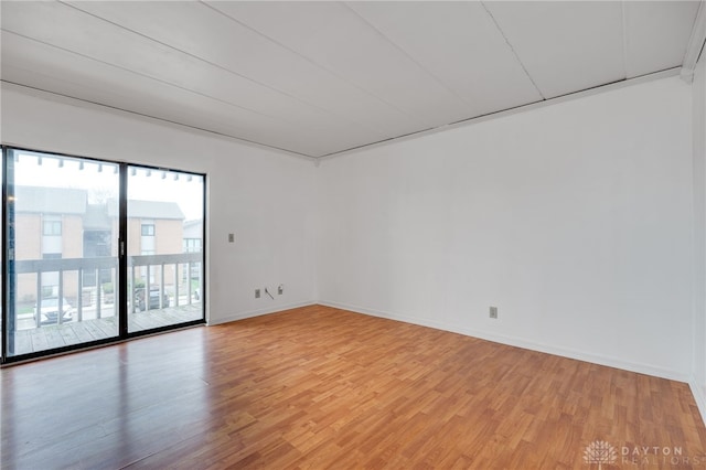spare room featuring light wood finished floors and baseboards