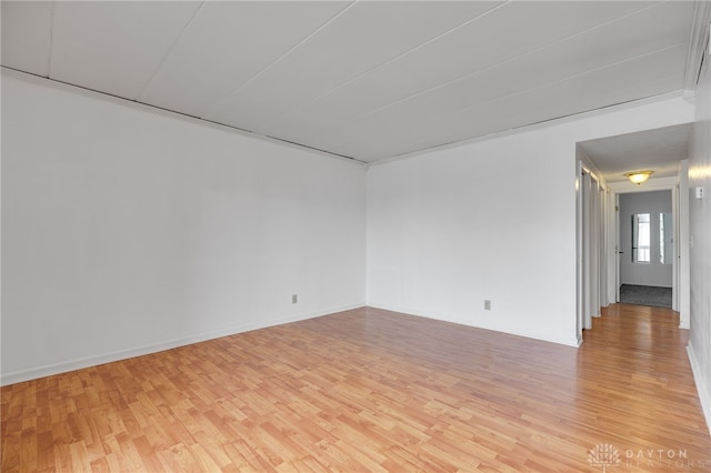 unfurnished room with light wood-style flooring and baseboards
