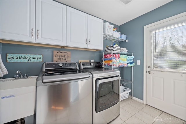 laundry area with baseboards, separate washer and dryer, a sink, cabinet space, and light tile patterned flooring