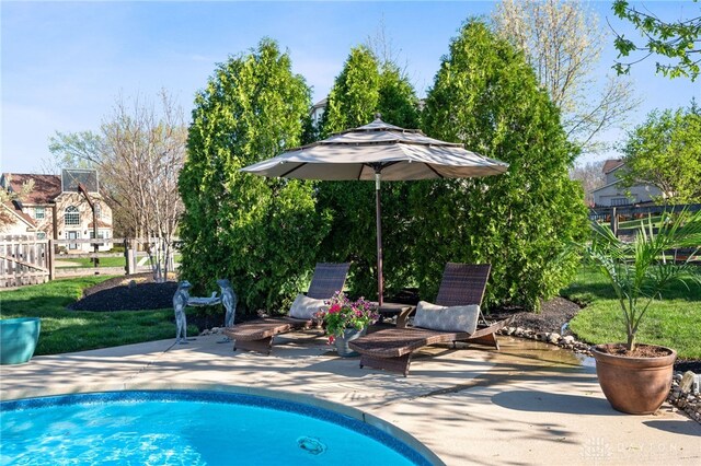 pool with a patio area and fence