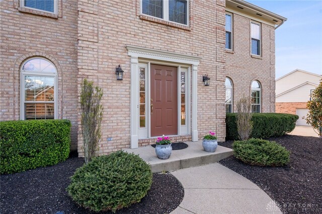 view of exterior entry with brick siding