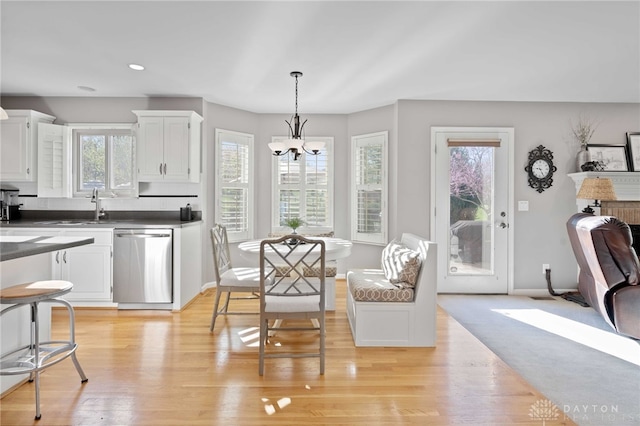 dining area with baseboards, light wood-type flooring, an inviting chandelier, and recessed lighting
